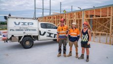 VIP Steel Frames & Trusses team photo next to steel and timber frames on job site