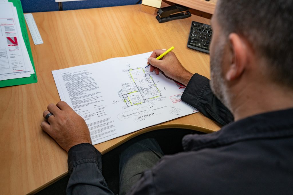 VIP Frames & Trusses employee looking at floor plans in VIP Frames & Trusses office