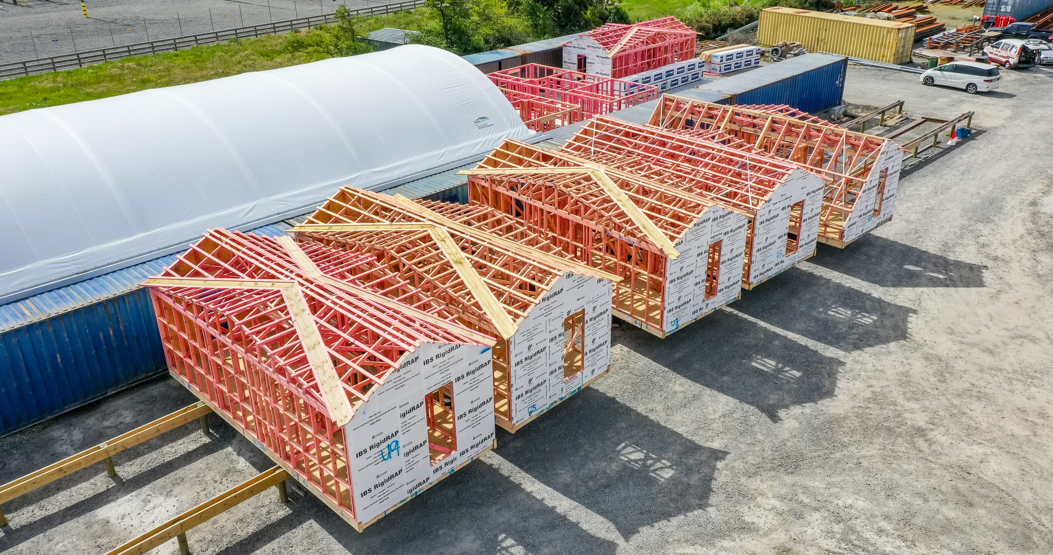 Five prefab timber pods lined up ready to be transported to site