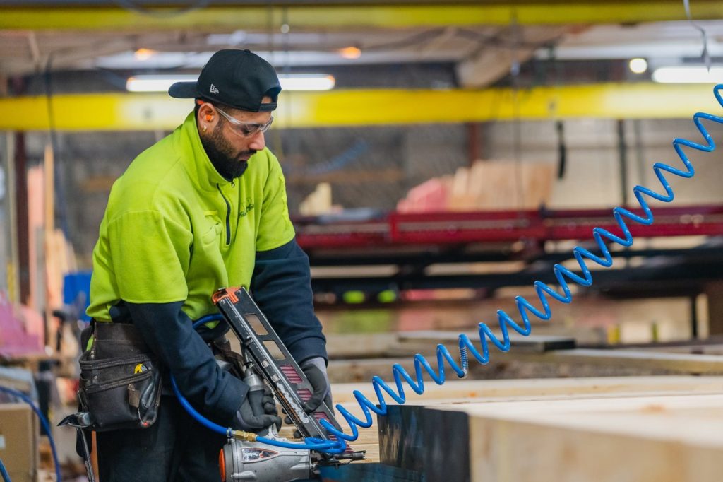 VIP Frames & Trusse staff member in factory using commercial nail gun