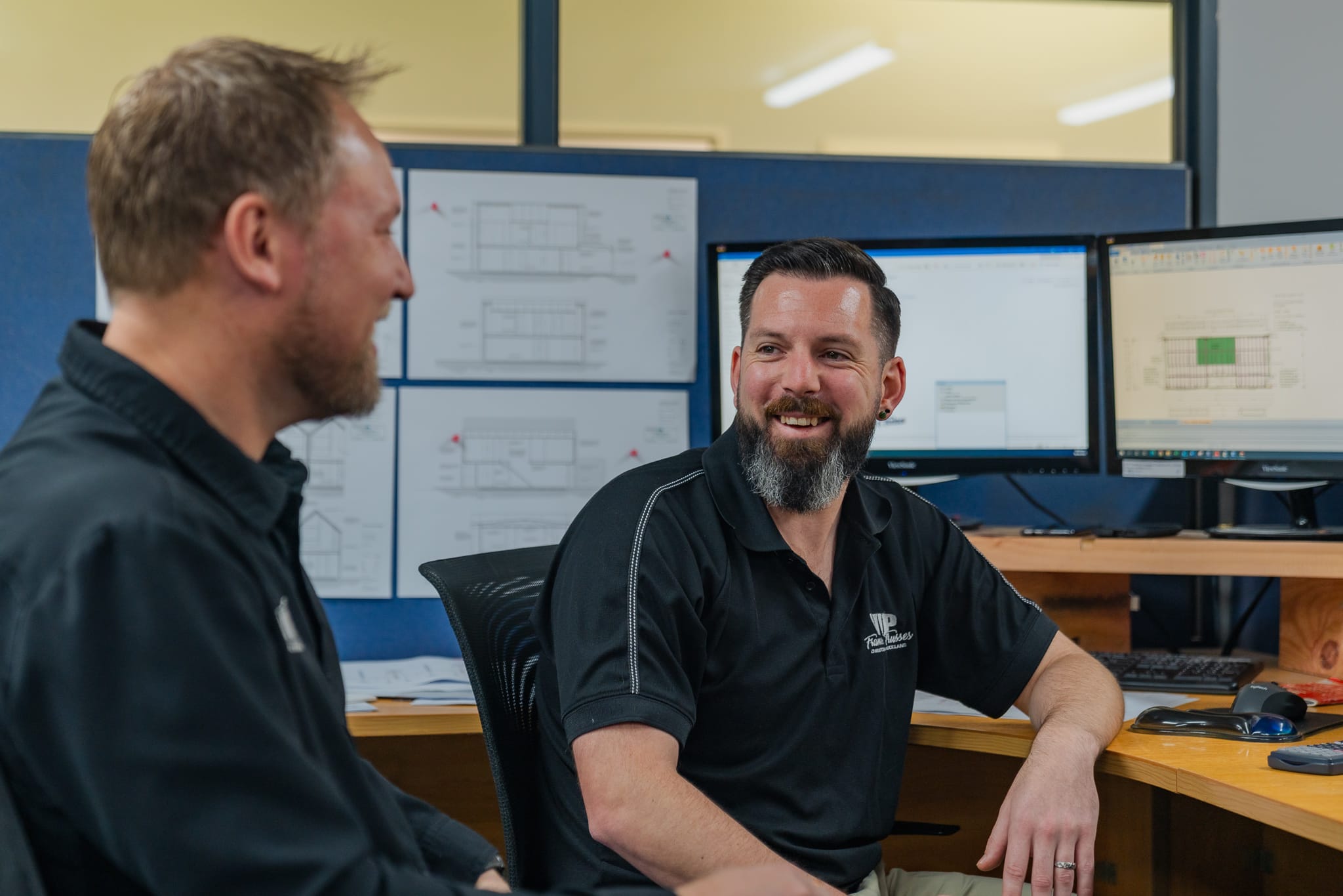 VIP Frames & Trusses staff talking by computers in office Christchurch