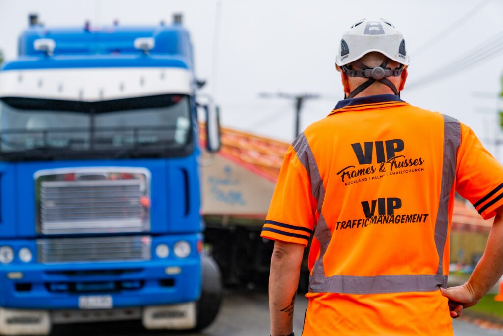 VIP Frames and Trusses employee wearing VIP Frames and Trusses branded high-vis polo in front of a truck